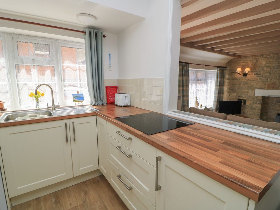 A kitchen with sink and stove at Claire Cottage in Swanage