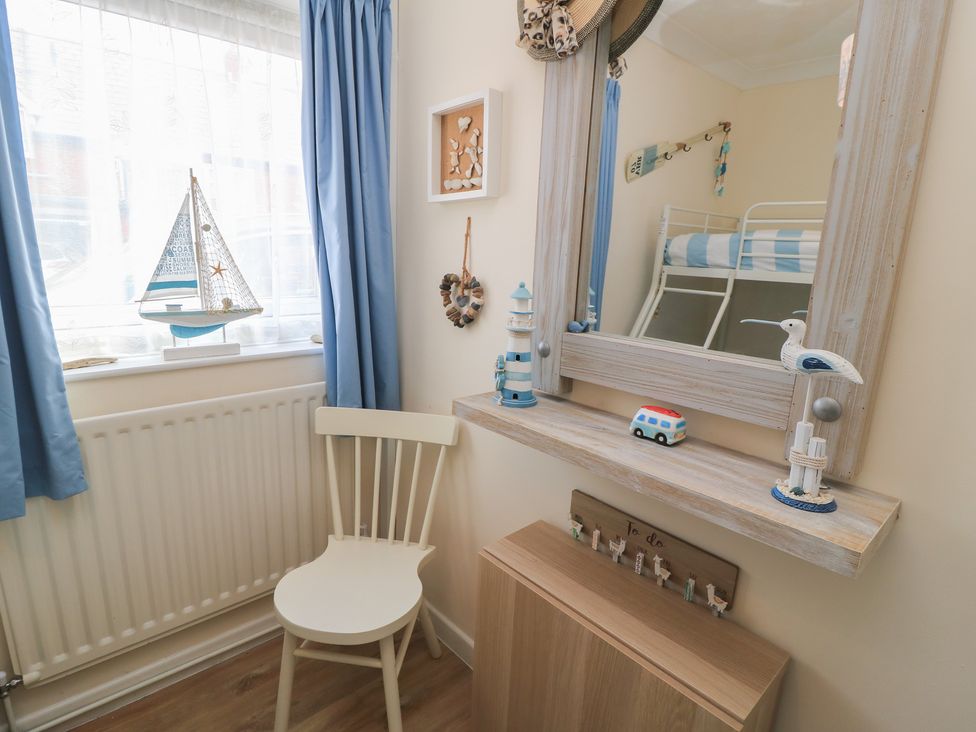A bedroom with a sailboat and mirror at Claire Cottage in Swanage