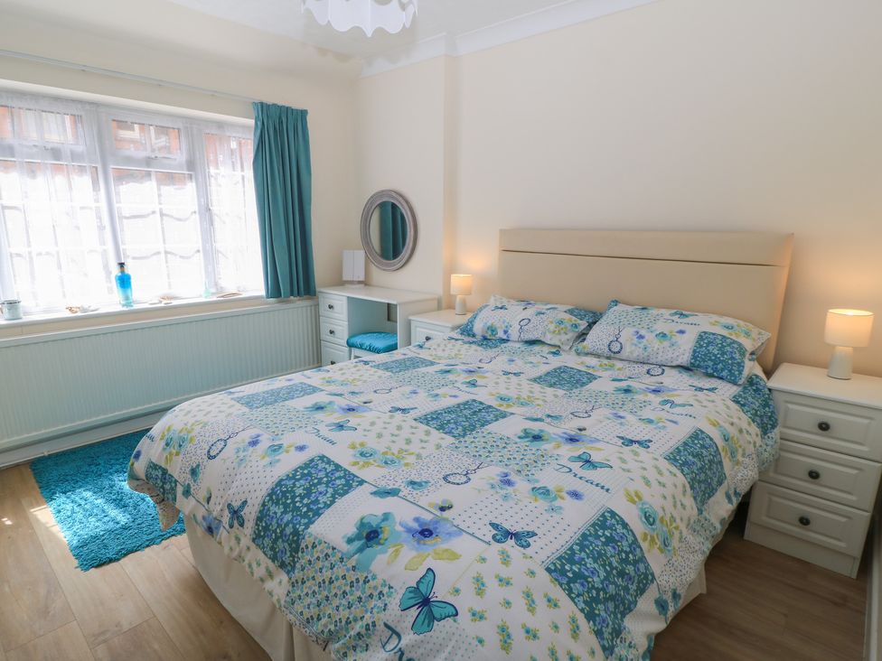 A bedroom with a bed and a mirror at Claire Cottage in Swanage