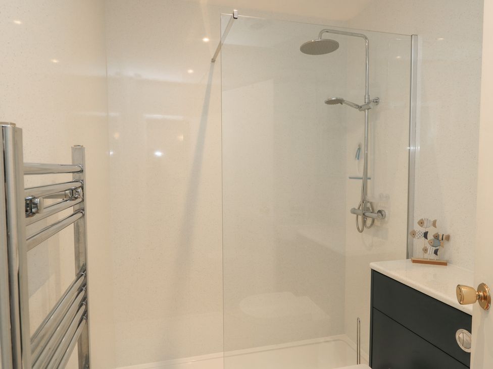 A bathroom with a shower and towel rail at Claire Cottage in Swanage
