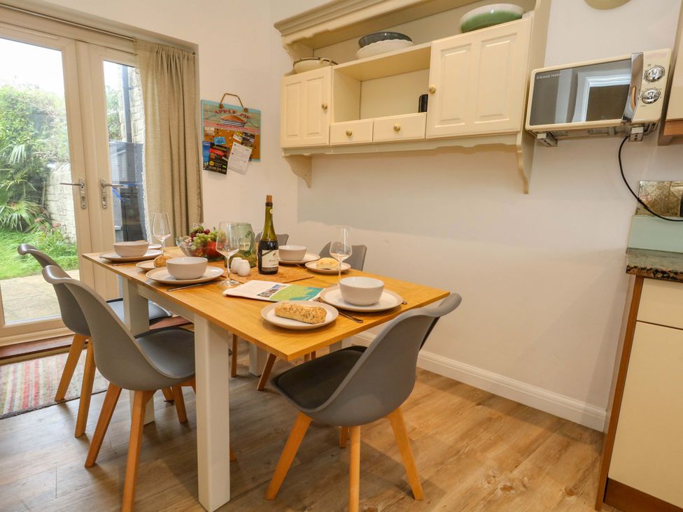 A kitchen with a dining table set for a meal at Corner Cottage Preston