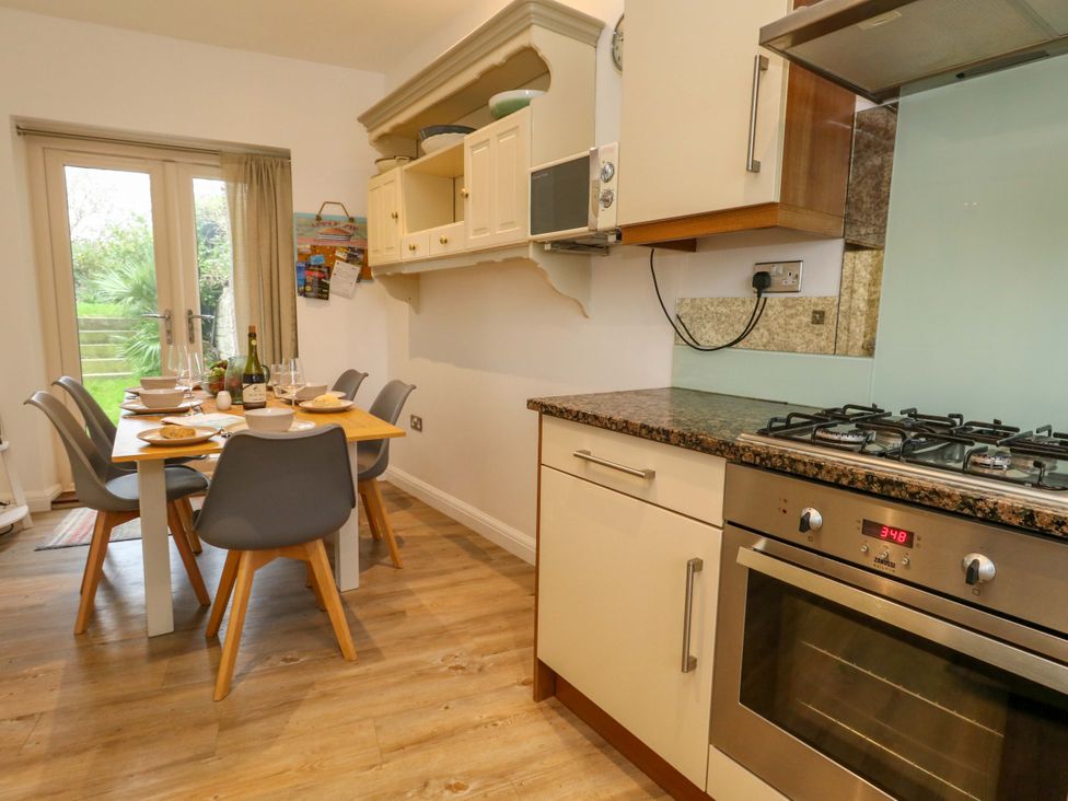A kitchen with a dining table and cooking appliances at Corner Cottage in Preston