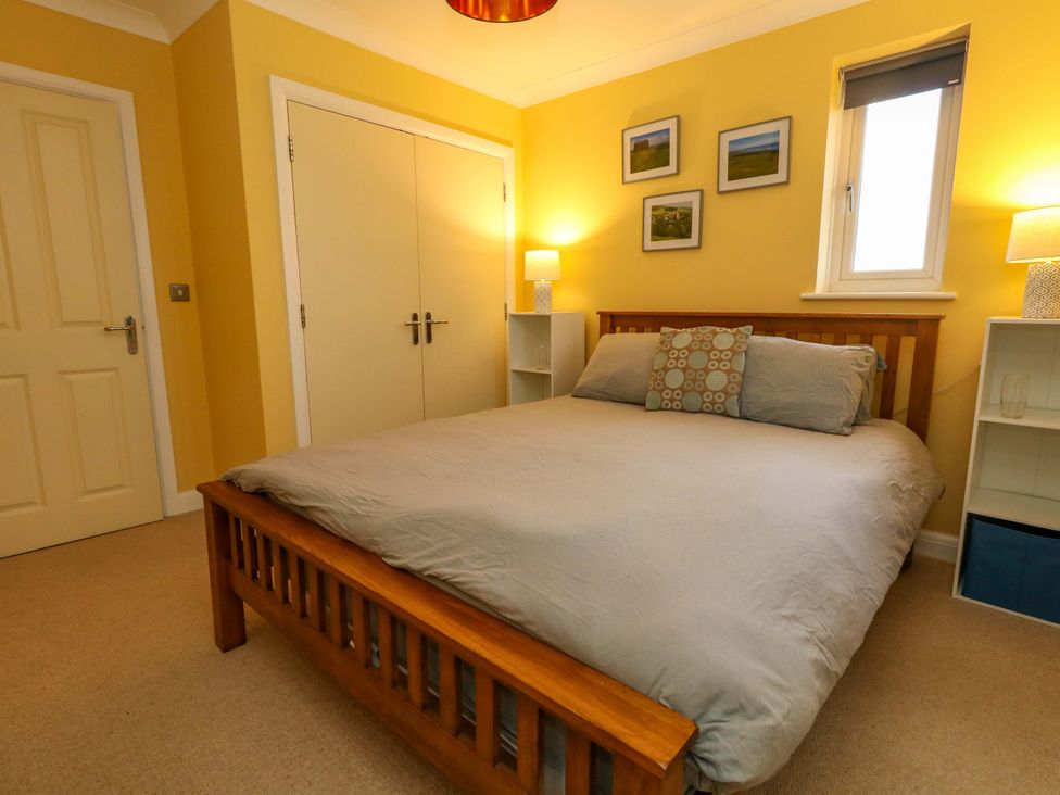 A bedroom featuring a bed with bedding and lamps at Corner Cottage in Preston