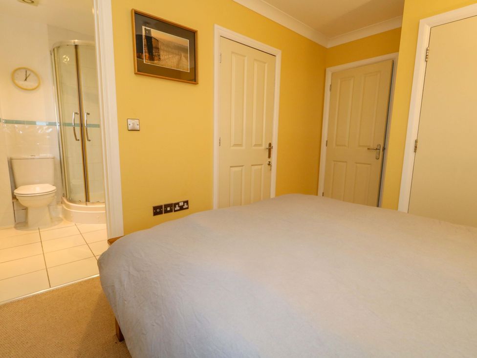 A bedroom with an en-suite bathroom at Corner Cottage Preston