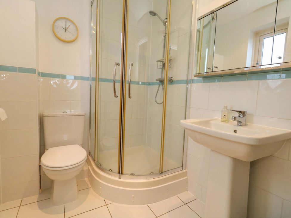 A bathroom with a shower, toilet, and sink at Corner Cottage in Preston