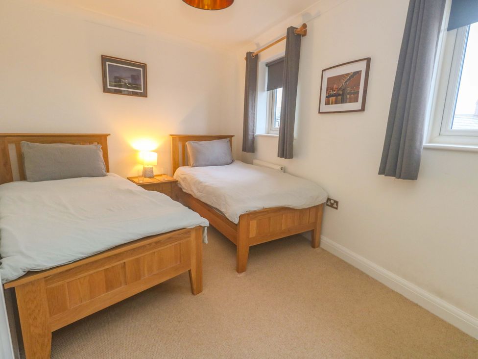 A bedroom with two beds and a lamp at Corner Cottage in Preston