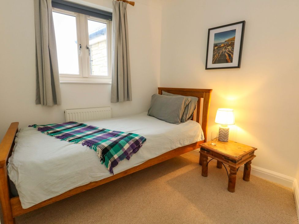 A bedroom with a bed and lamp at Corner Cottage in Preston