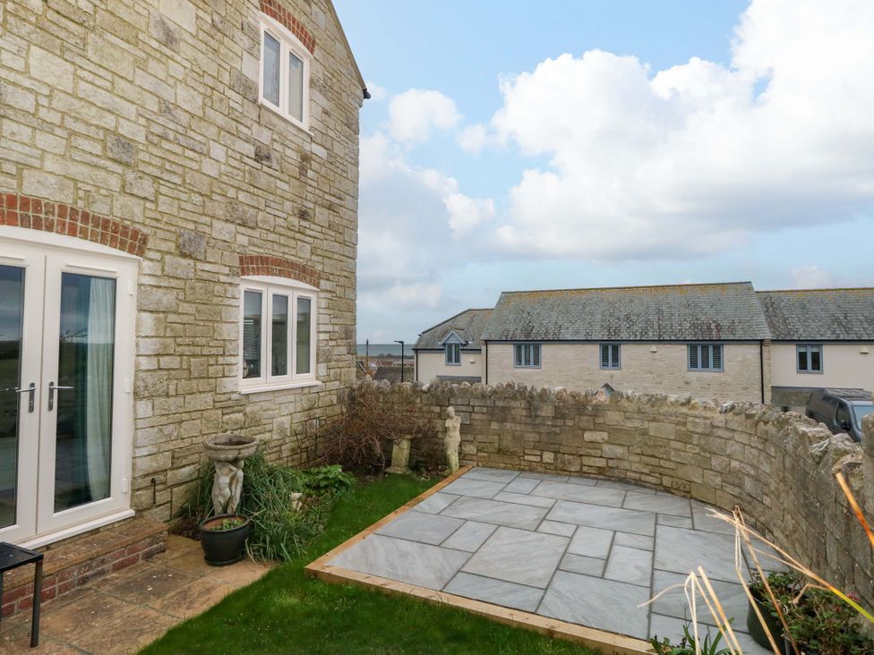 A garden with a stone wall and patio at Corner Cottage in Preston