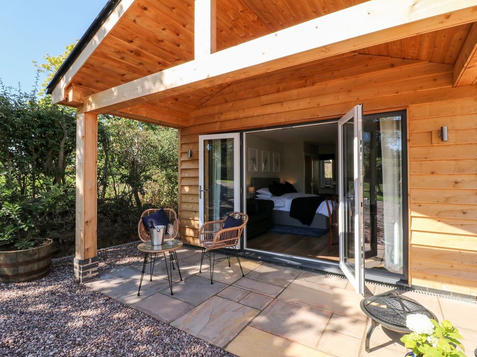 An outdoor area with a wooden cabin and patio furniture at The Lodge at Middleton House in Stoke-on-Trent
