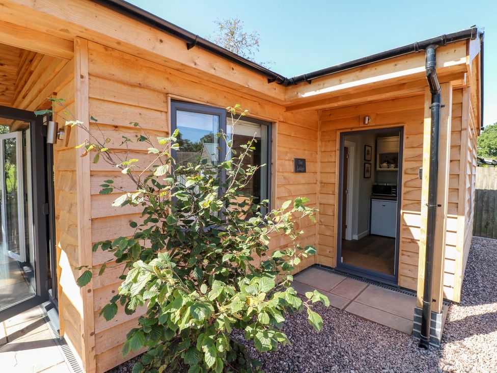 A wooden structure with a door and windows at The Lodge at Middleton House in Stoke-on-Trent