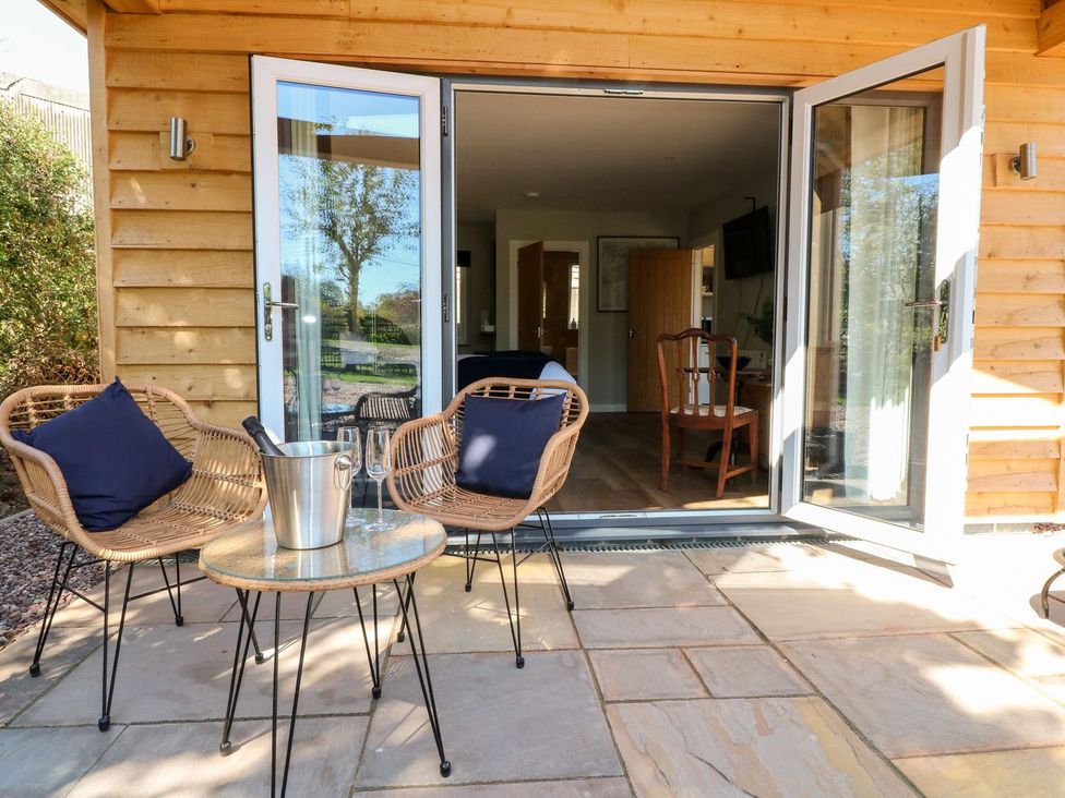 An outdoor seating area with chairs and a table at The Lodge at Middleton House in Stoke-on-Trent