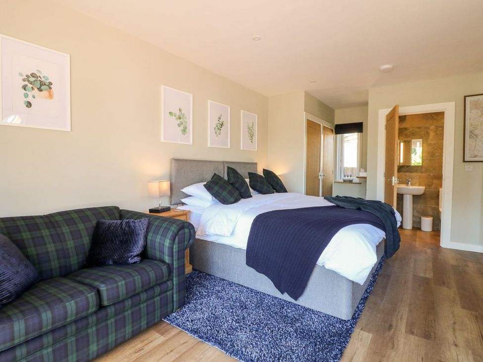 A bedroom with a bed and a sofa at The Lodge at Middleton House Stoke-on-Trent