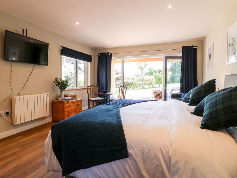 A bedroom with a bed and television at The Lodge at Middleton House Stoke-on-Trent