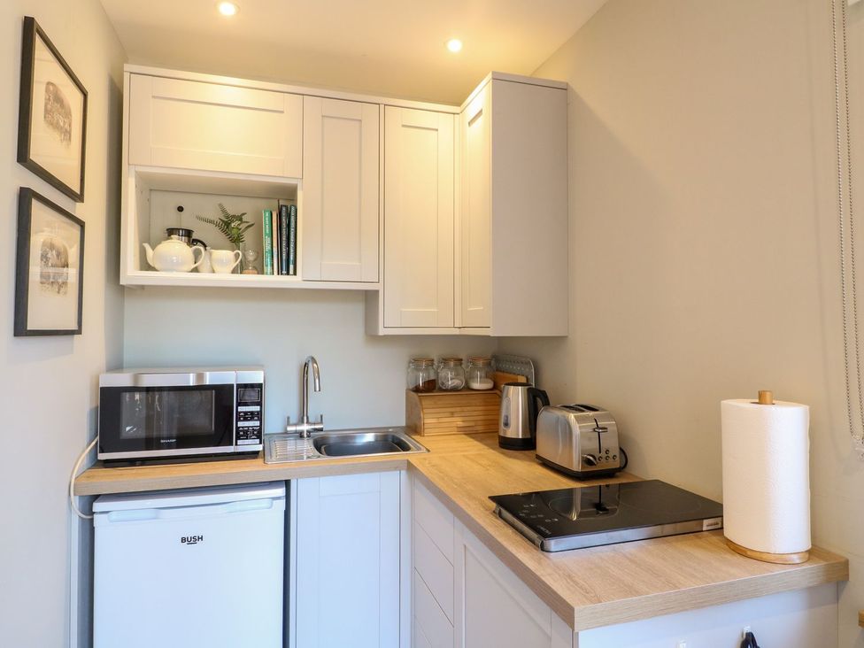 A kitchen with a refrigerator and microwave at The Lodge at Middleton House Stoke-on-Trent