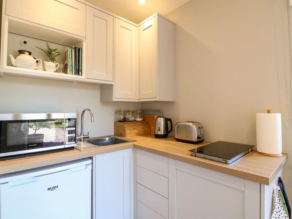 A kitchen with a microwave, sink, kettle, toaster and utensils at The Lodge at Middleton House Stoke-on-Trent