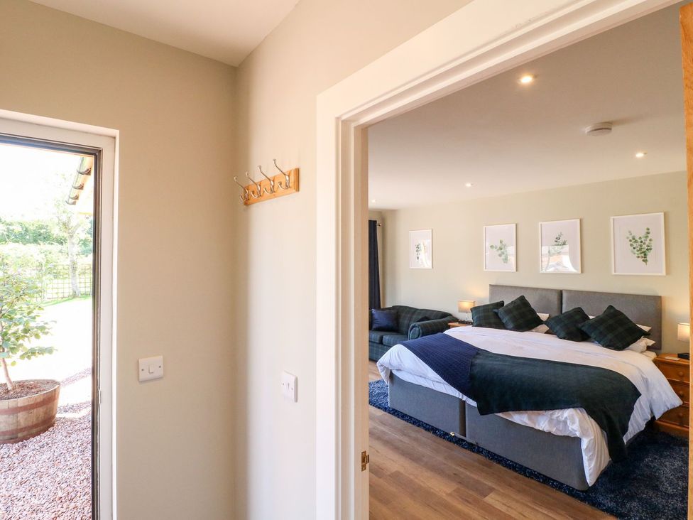 A bedroom with a bed and sofa at The Lodge at Middleton House Stoke-on-Trent