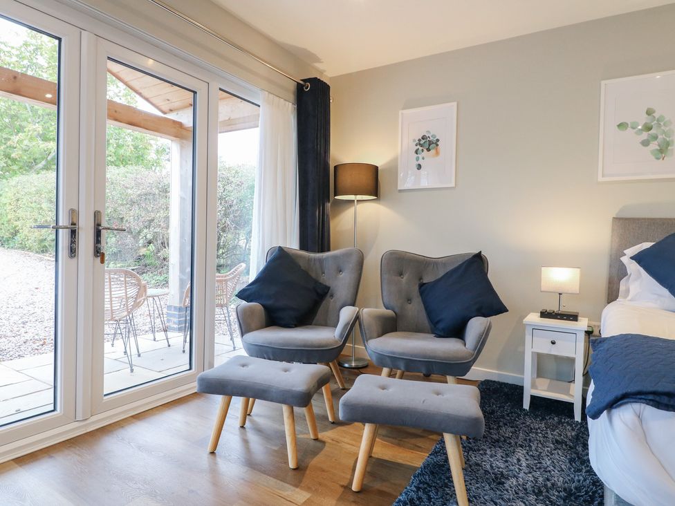 A living room with two armchairs and a footstool at The Lodge at Middleton House Middleton Green near Stone