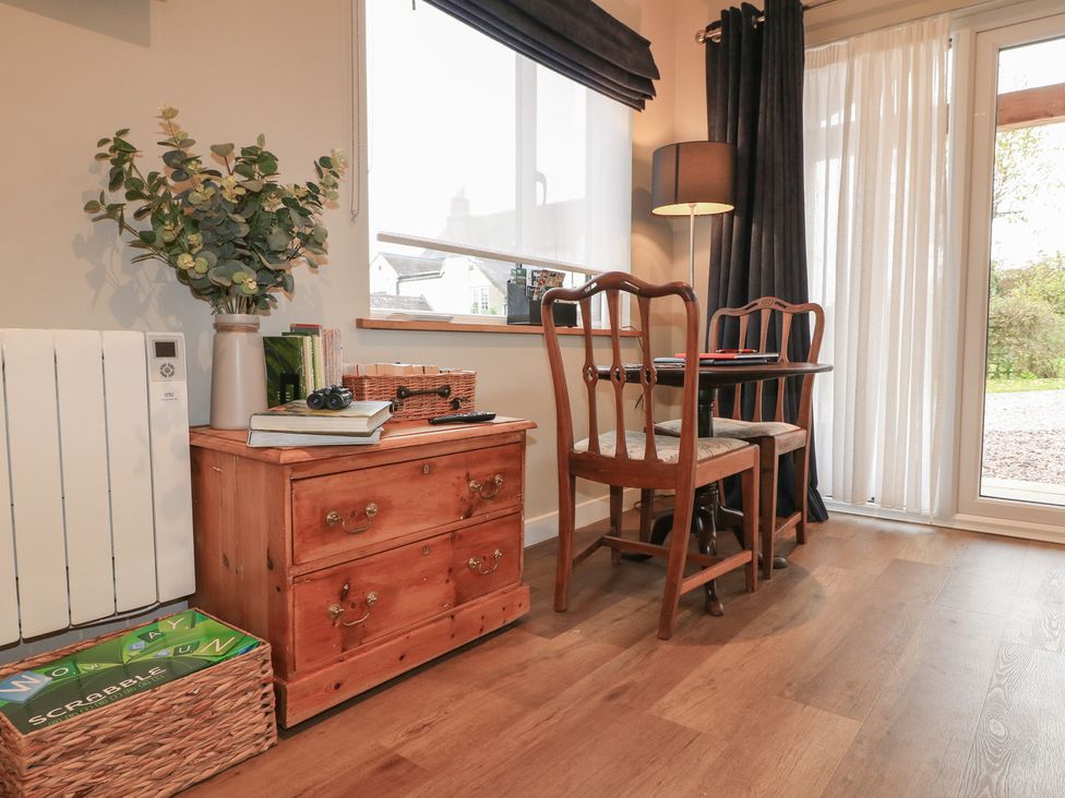 A dining room with a wooden table and chairs at The Lodge at Middleton House Middleton Green near Stone