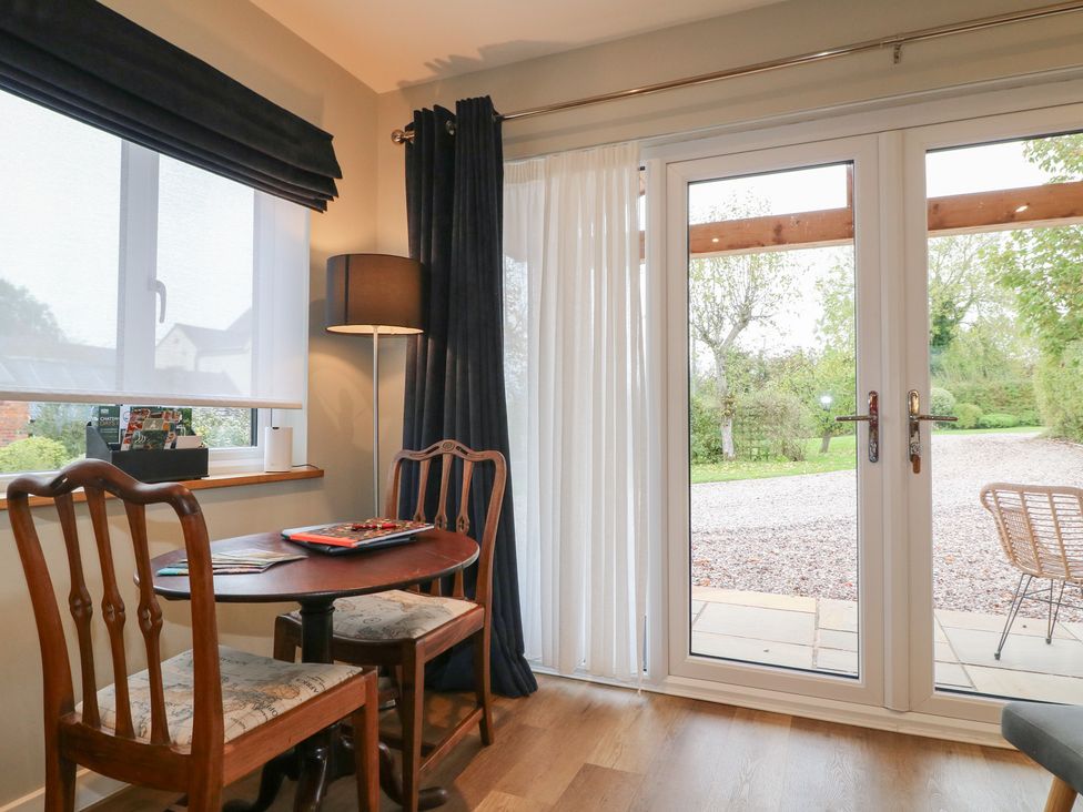 A snug with table and chairs near patio doors at The Lodge at Middleton House in Middleton Green near Stone