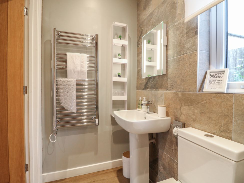 A bathroom with a towel rail, sink, and toilet at The Lodge at Middleton House in Middleton Green near Stone
