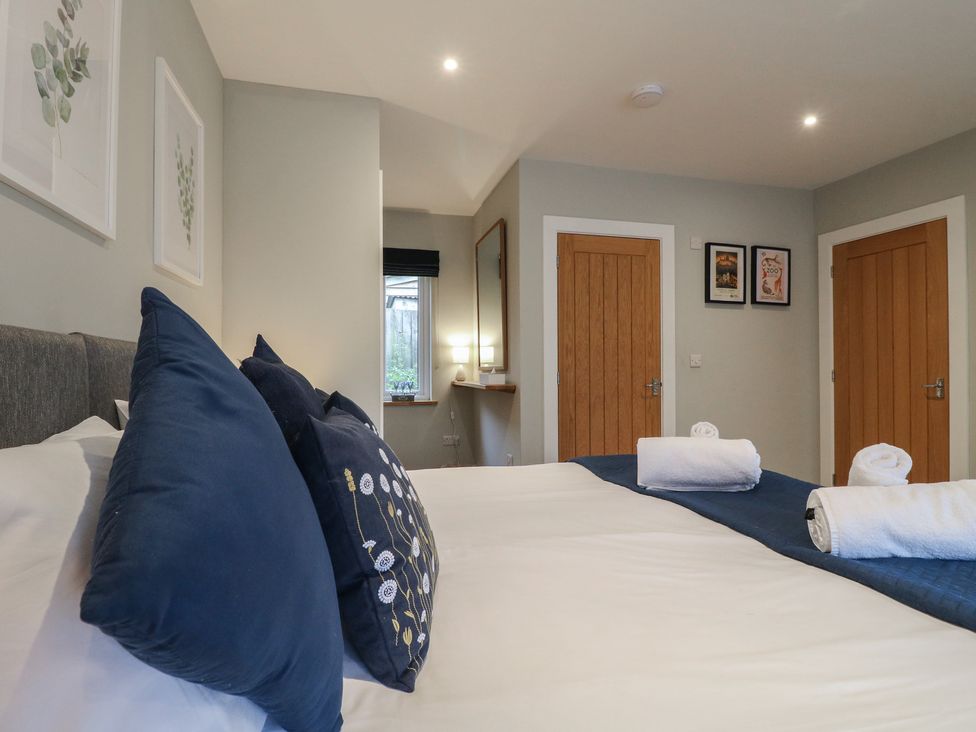 A bedroom with two doors and towels on the bed at The Lodge at Middleton House Middleton Green near Stone