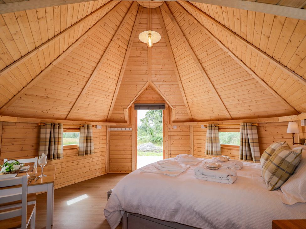 A bedroom with a bed and table at Little Luxe Lodges in Balmacara near Kyle of Lochalsh