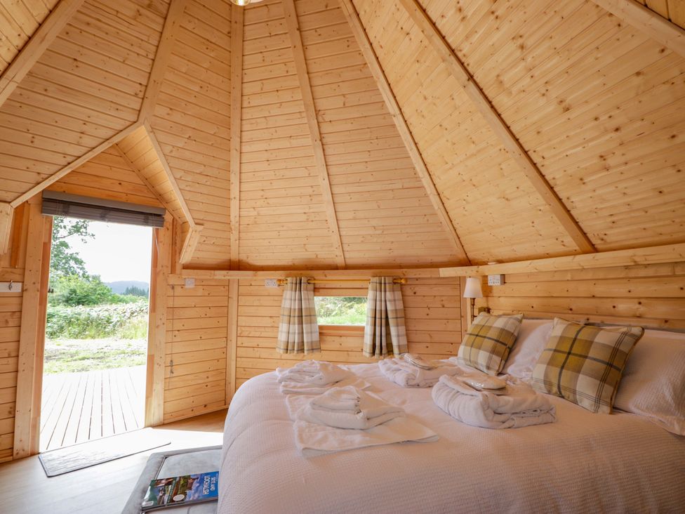 A bedroom with a bed and wooden walls at Little Luxe Lodges Balmacara near Kyle of Lochalsh