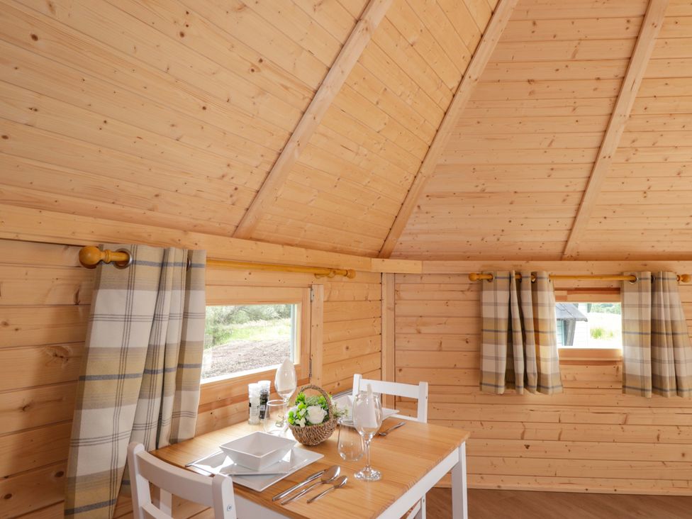 A dining room with a table and chairs at Little Luxe Lodges Balmacara near Kyle of Lochalsh