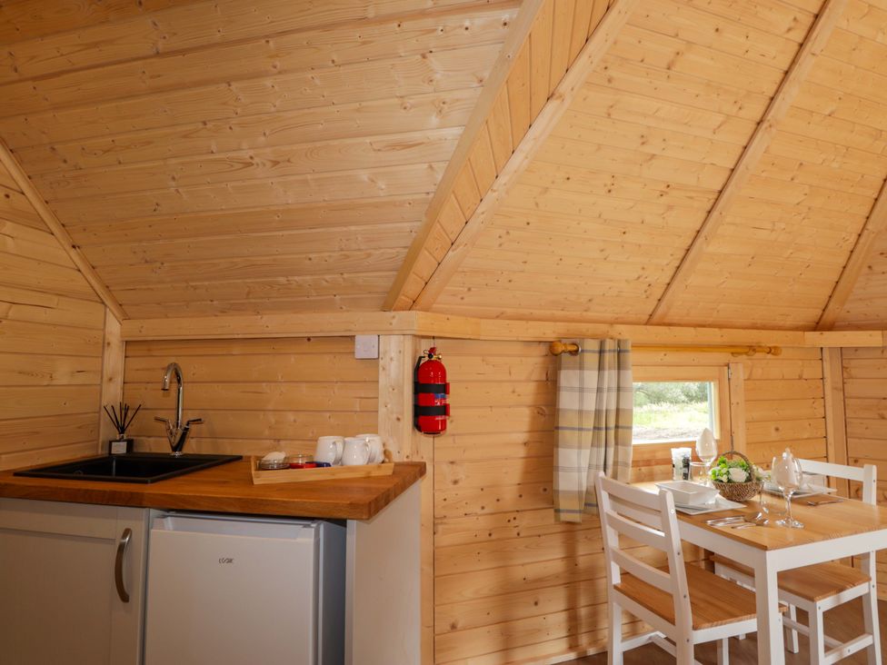 A kitchen area with a sink and table at Little Luxe Lodges Balmacara near Kyle of Lochalsh