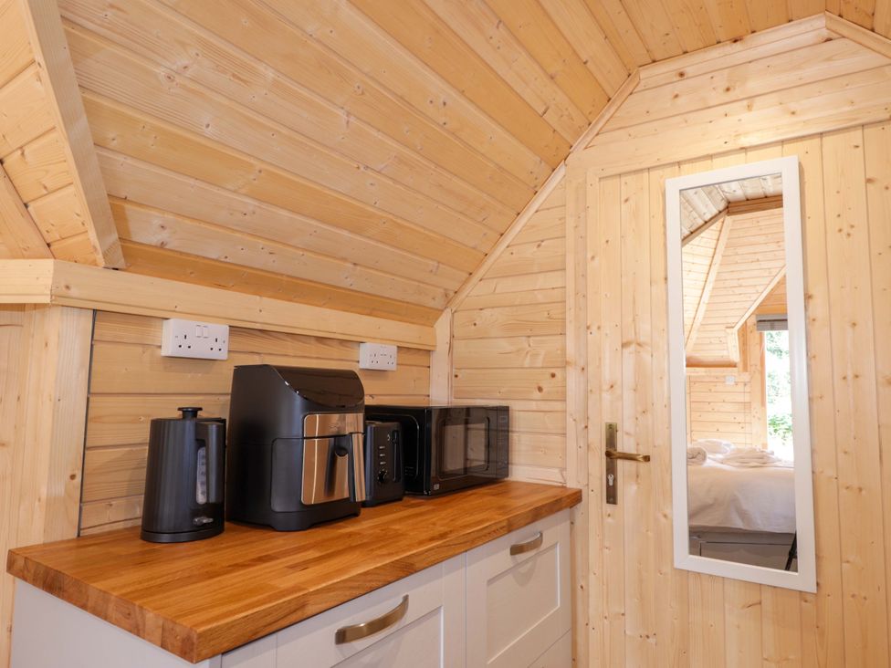 A kitchen with appliances and a mirror at Little Luxe Lodges in Balmacara near Kyle of Lochalsh
