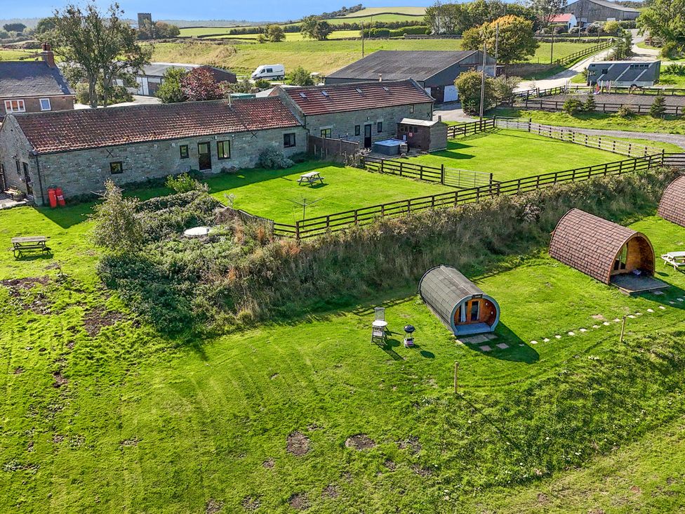 An outdoor setting with buildings, tents, and a picnic table at Hare Pod, Staintondale near Burniston