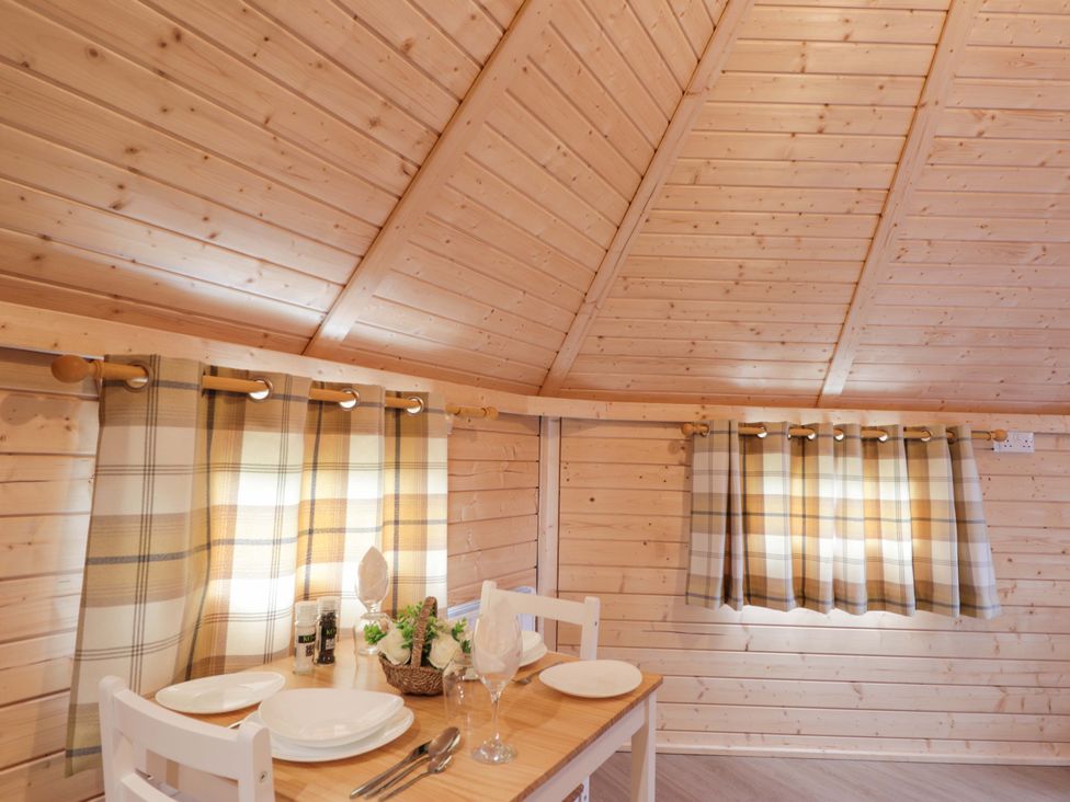 A dining room with a table set for a meal at Little Luxe Lodges 2 Balmacara near Kyle of Lochalsh