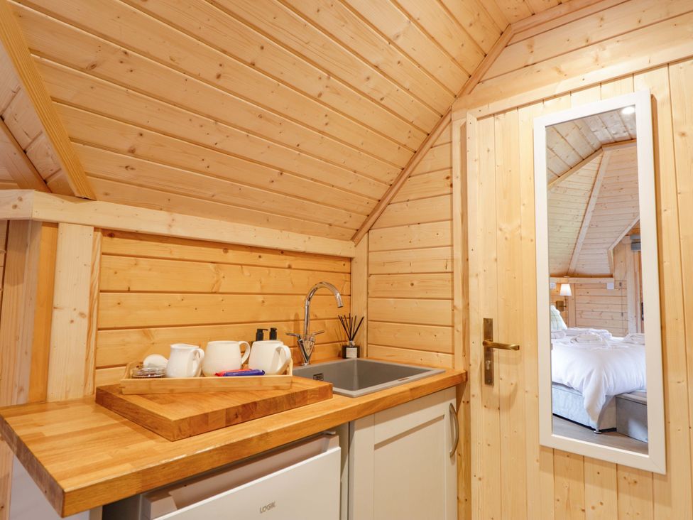A kitchen area with a sink and refrigerator at Little Luxe Lodges 2 Balmacara near Kyle of Lochalsh