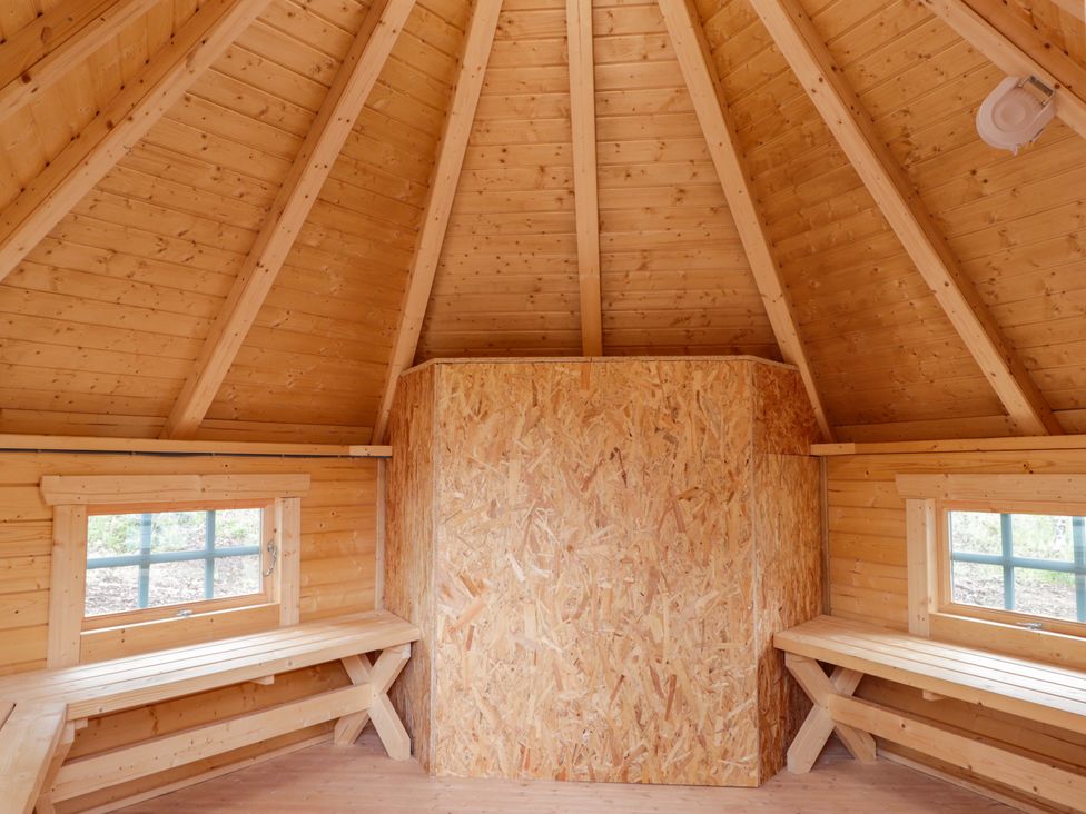 An indoor space with wooden walls and benches at Little Luxe Lodges 2 Balmacara near Kyle of Lochalsh
