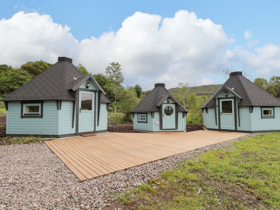 Three cabins on a wooden deck at Little Luxe Lodges 2 in Balmacara near Kyle of Lochalsh