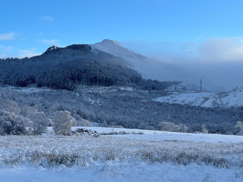 A snowy landscape with mountains and trees at Little Luxe Lodges 2 near Balmacara