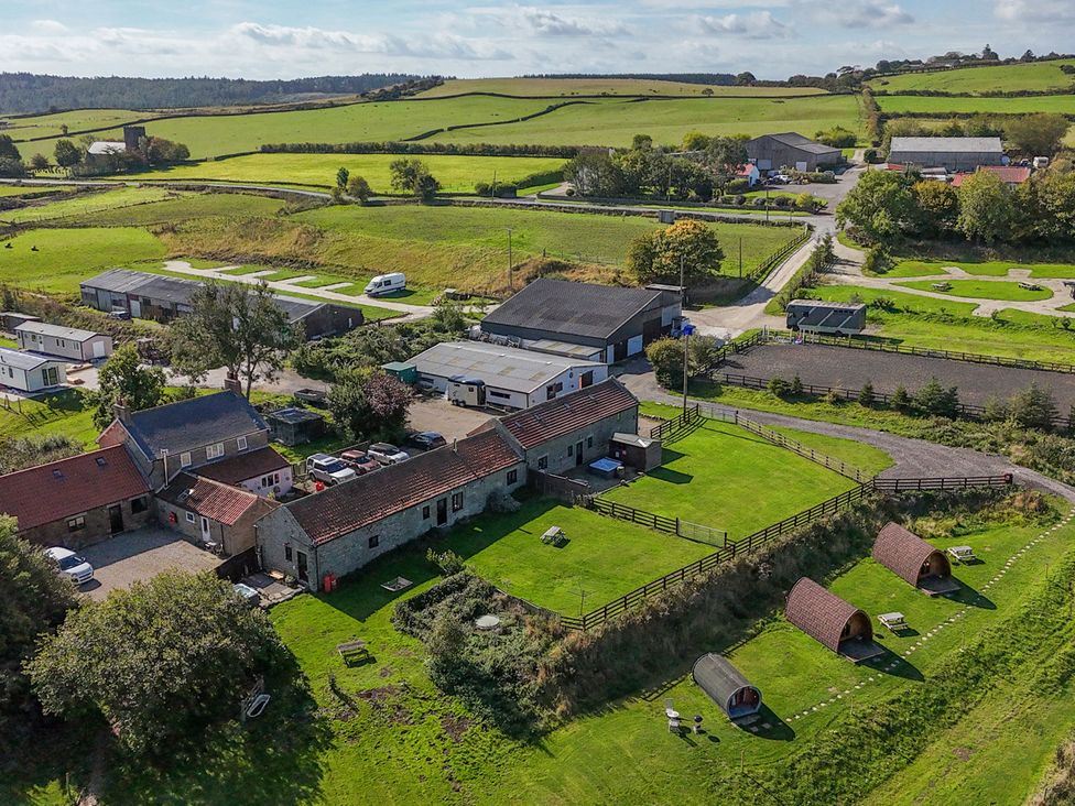 An outdoor view of a property with buildings and fields at Woodpeckers Shepherds hut Staintondale near Burniston
