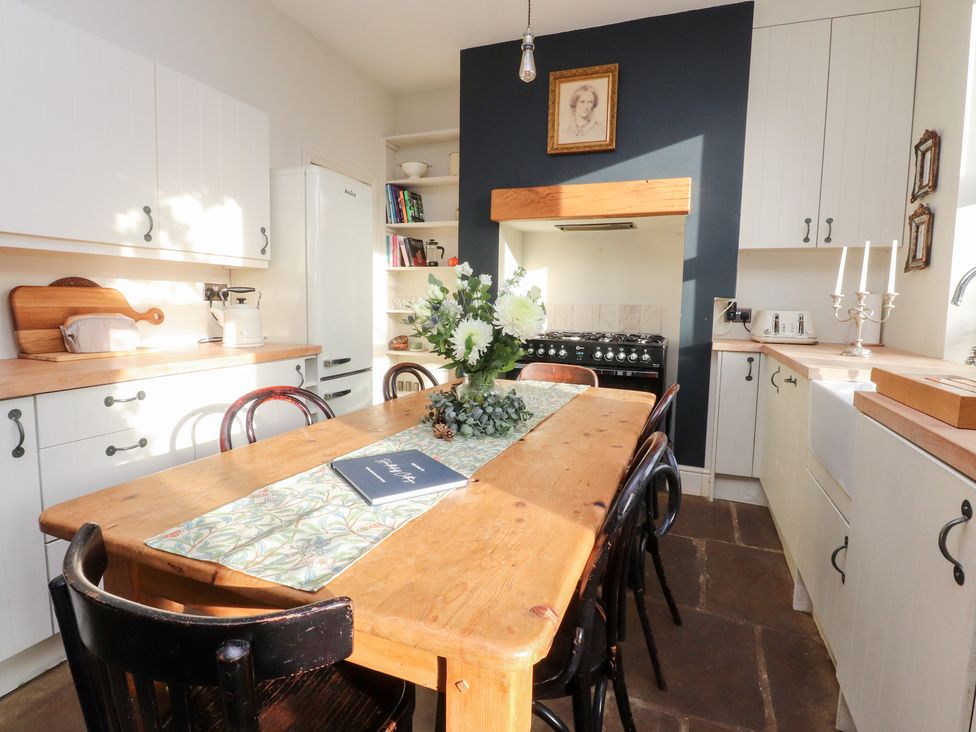A kitchen with a table and chairs at Heathcliff Cottage