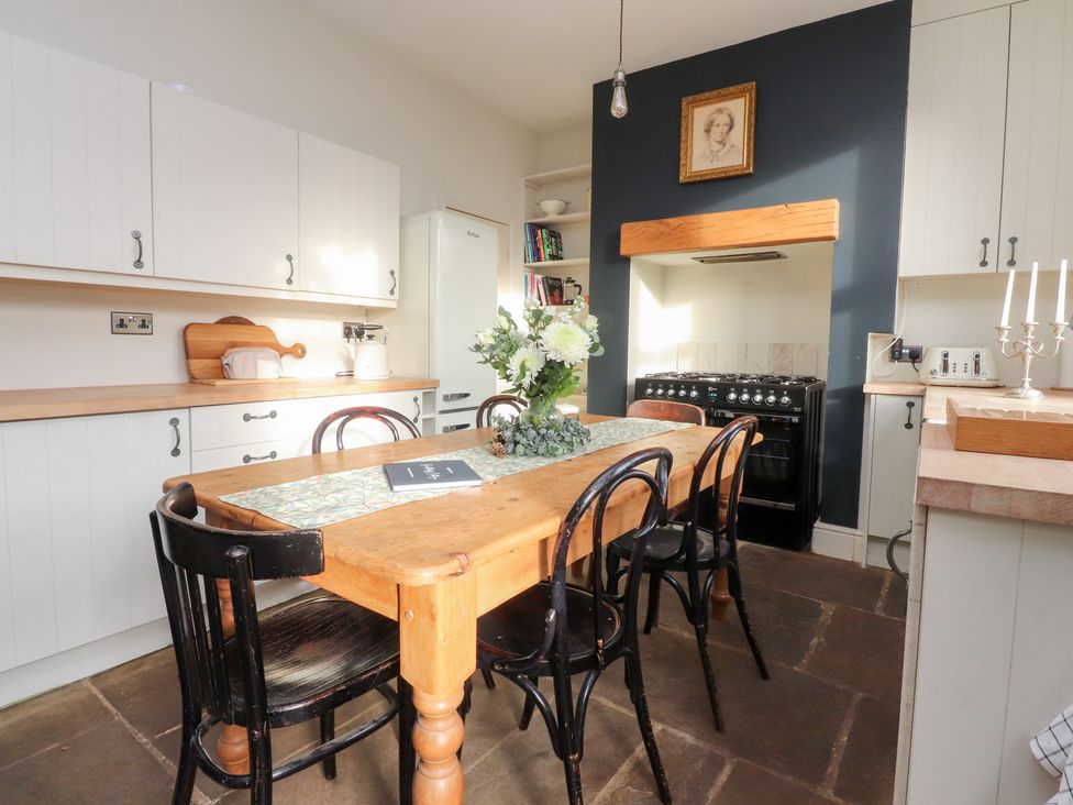 A kitchen with a table and chairs at Heathcliff Cottage