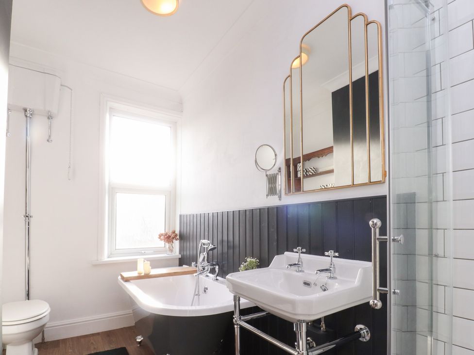 A bathroom with a bathtub, sink, and shower at Heathcliff Cottage