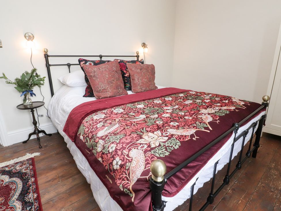 A bedroom with a bed and side table at Heathcliff Cottage