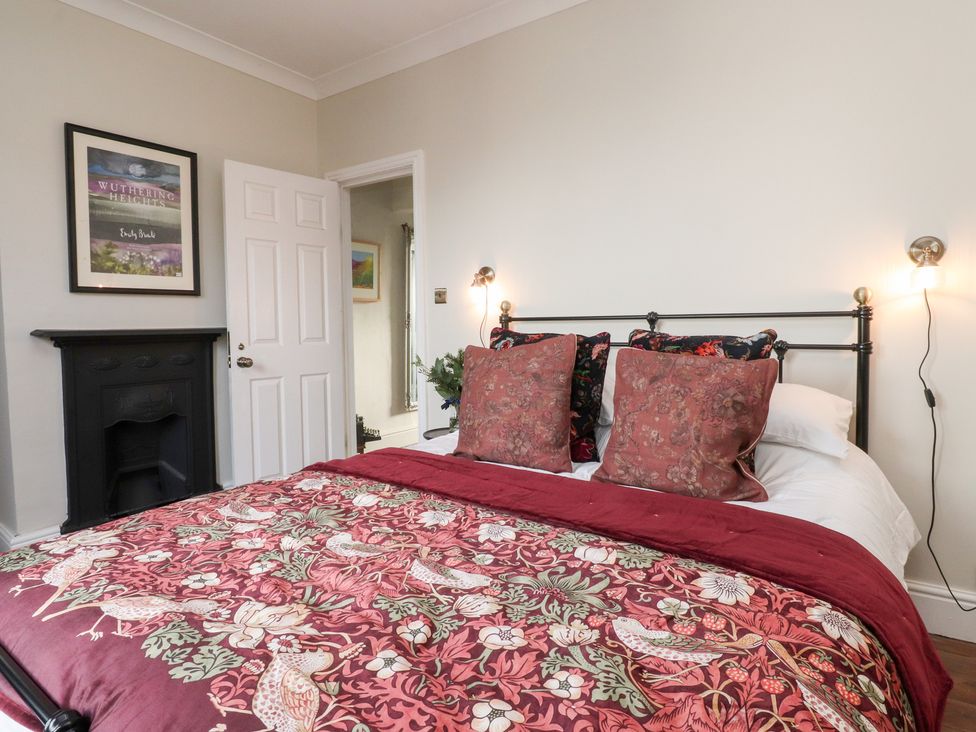 A bedroom with a bed and artwork on the wall at Heathcliff Cottage