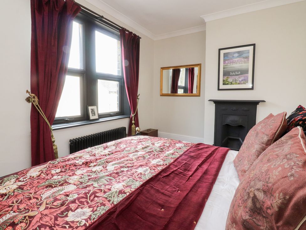 A bedroom with a bed and window at Heathcliff Cottage