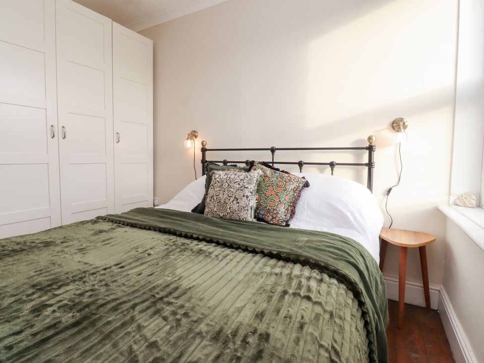A bedroom with a bed and wardrobe at Heathcliff Cottage