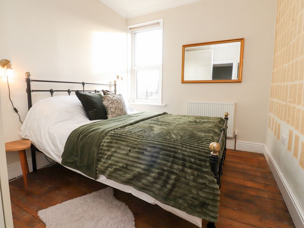 A bedroom with a bed and a window at Heathcliff Cottage