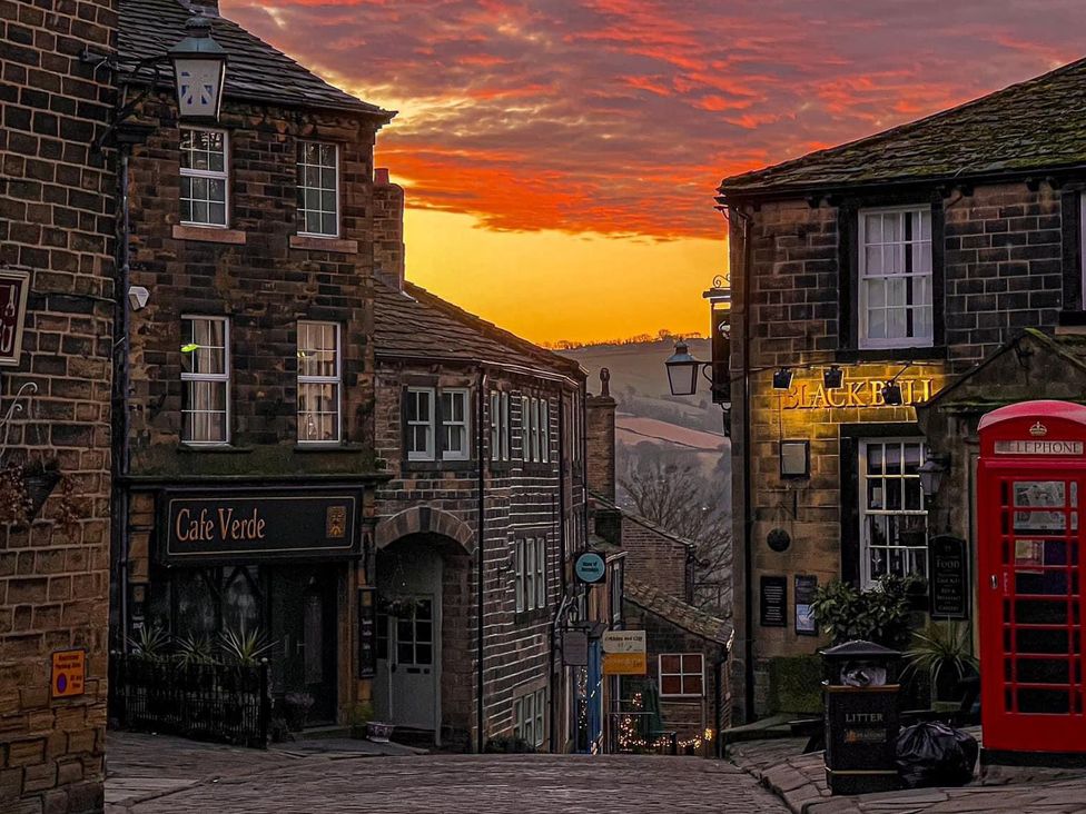 A street with buildings and a café at Heathcliff Cottage in Haworth
