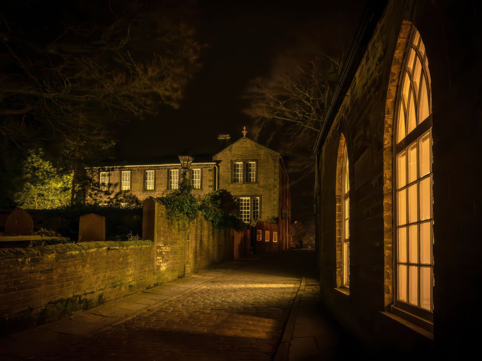 A building with illuminated windows at Heathcliff Cottage in Haworth