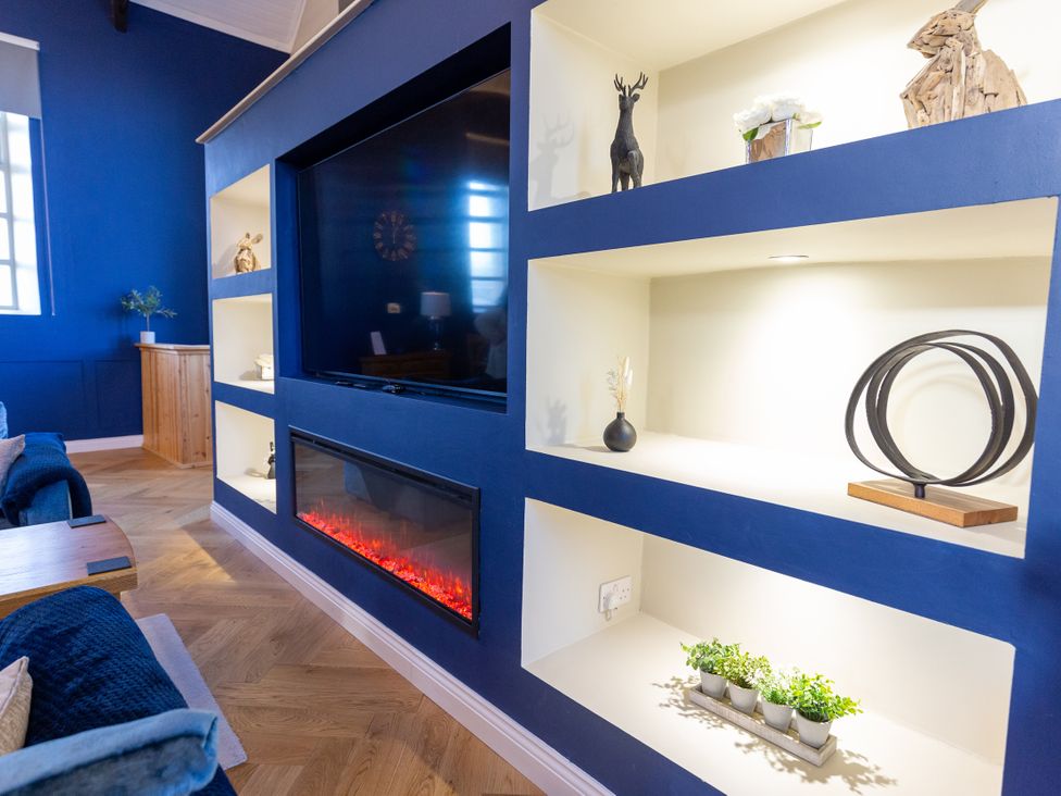 A living room with a television and electric fireplace at Moorsholm View in Saltburn-by-the-Sea
