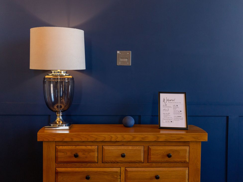 A living room with a lamp and a welcome sign at Moorsholm View Saltburn-by-the-Sea