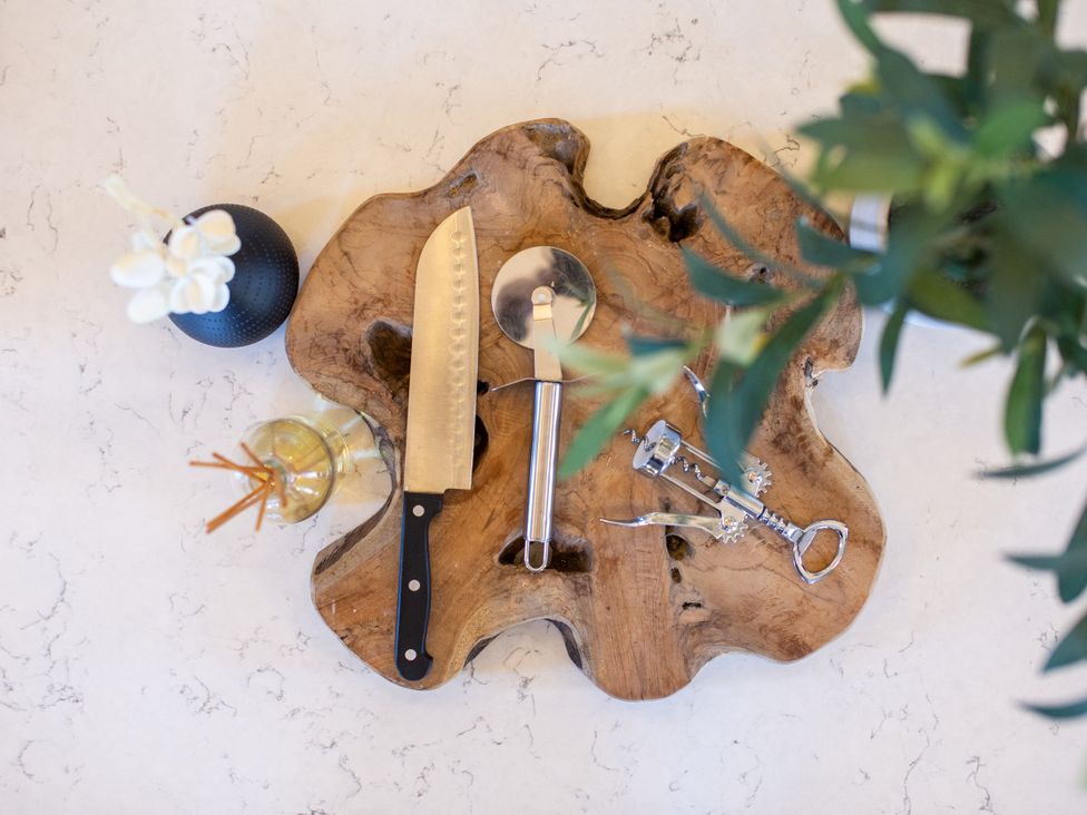 A chopping board with a knife, spoon, and corkscrew at Moorsholm View Saltburn-by-the-Sea